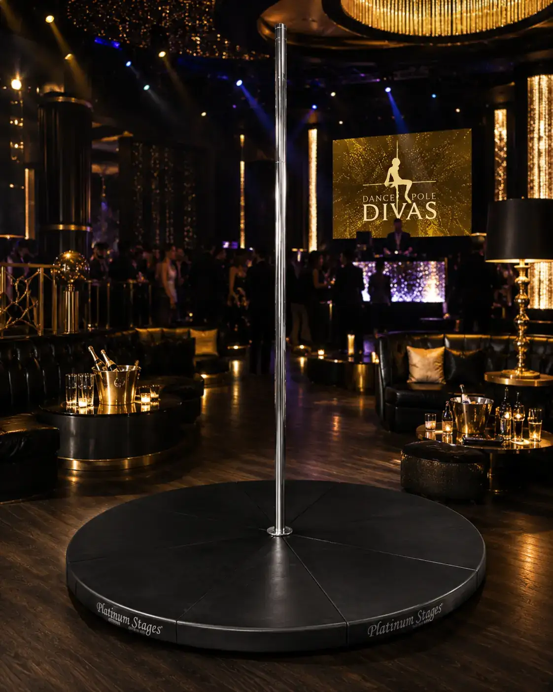 Self-standing chrome dance pole on a black stage in an upscale gold-lit nightclub